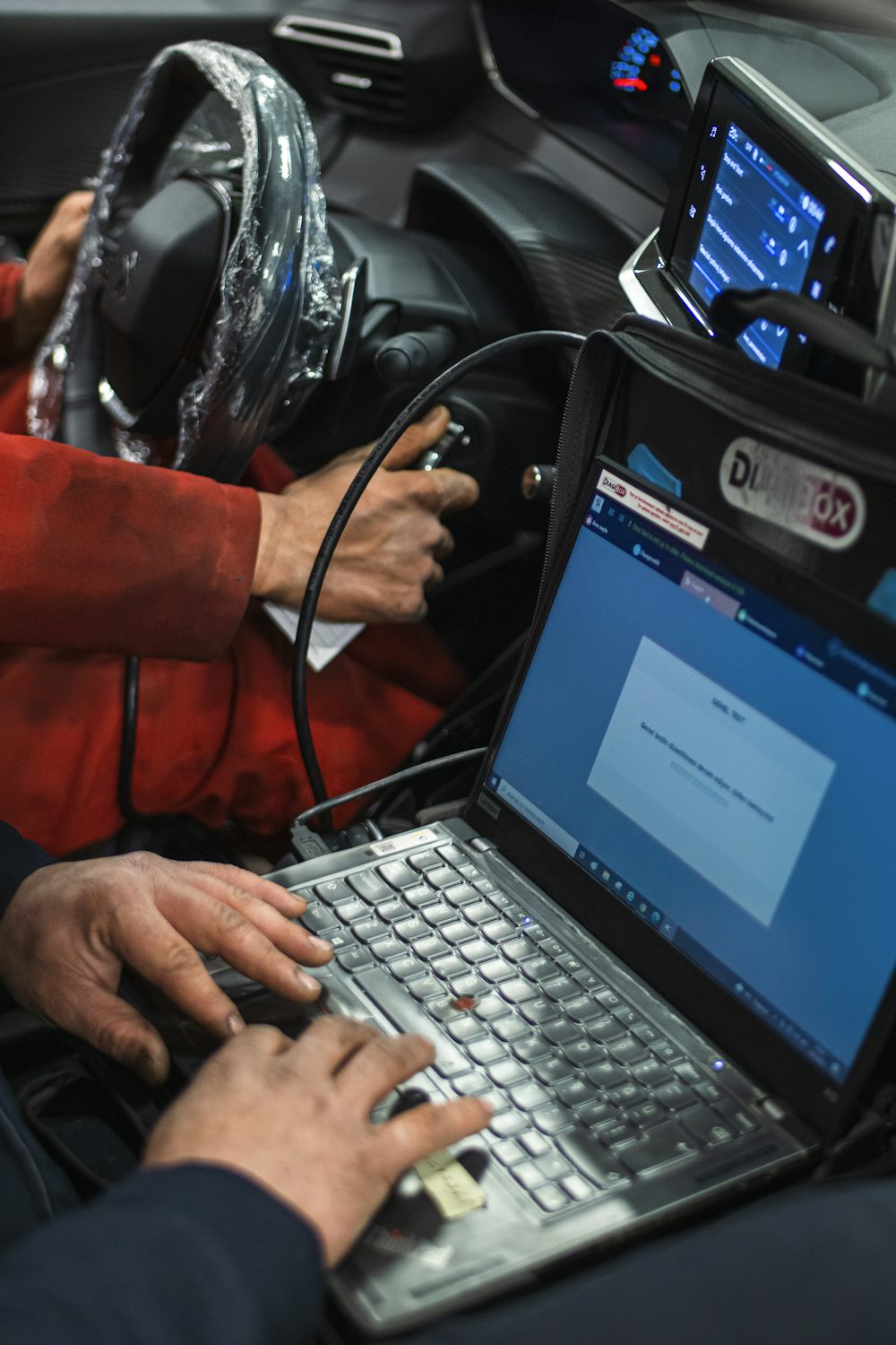 Diagnostic laptop plugged into a vehicle to read fault codes